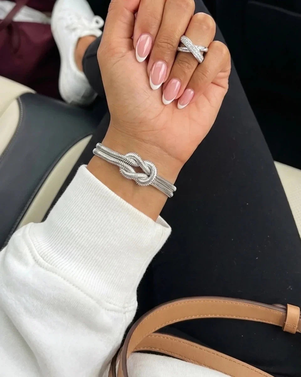 Woman wearing silver double knot herringbone bracelet with crossover ring - Monrich waterproof jewellery